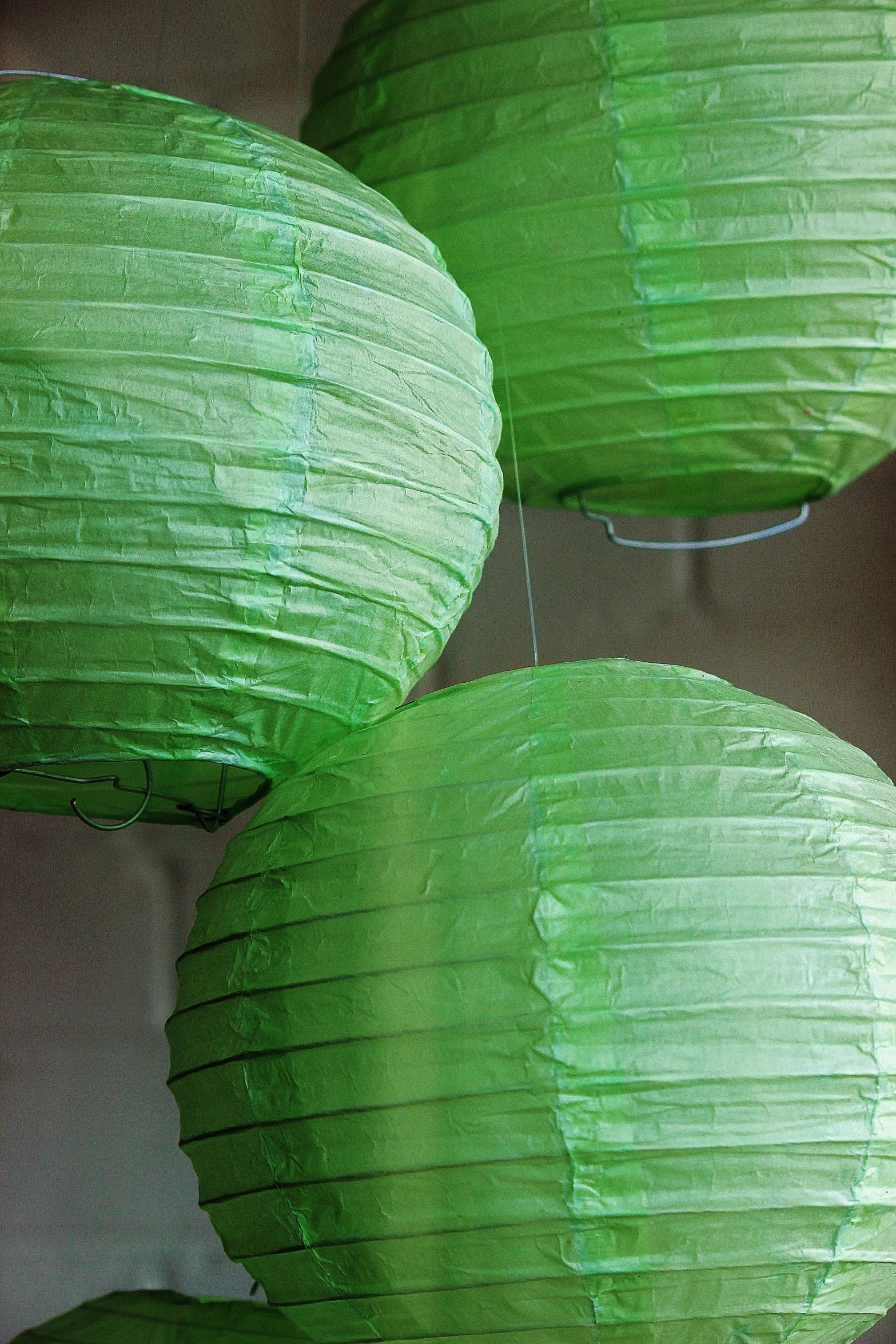 many green paper lanterns are displayed for people to view