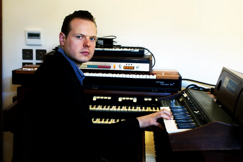 a man sitting in front of a pipe organ