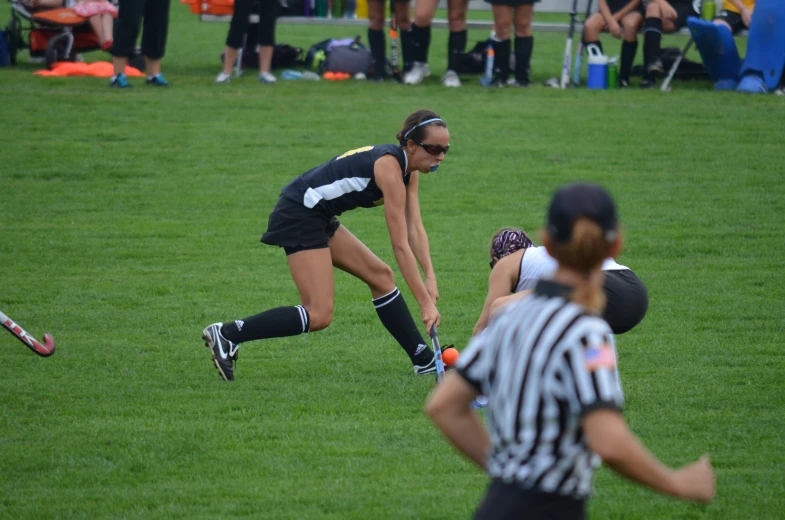 two girls are playing a game of soccer on the grass