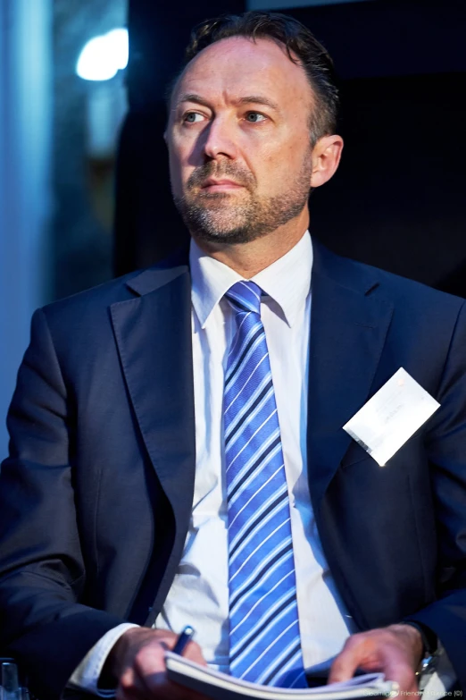 a man wearing a business suit and blue striped tie