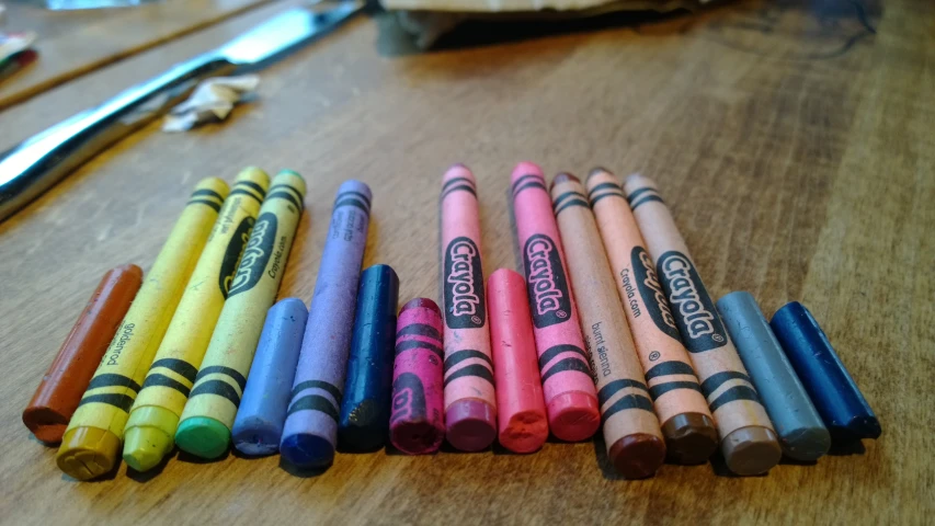 a number of crayons and some scissors on a table