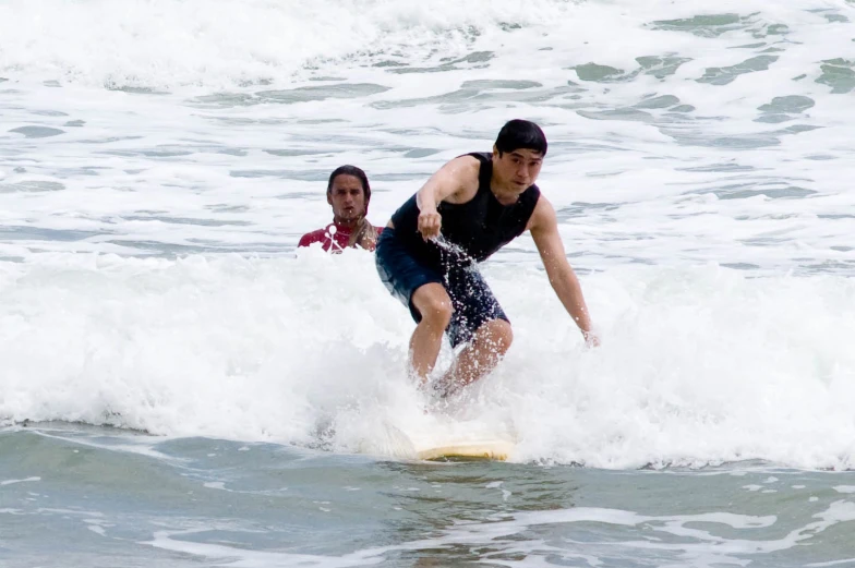 a man standing on top of a surfboard in the ocean