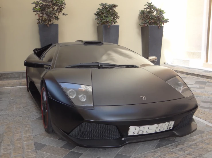 a sleek and black colored sports car parked inside a building