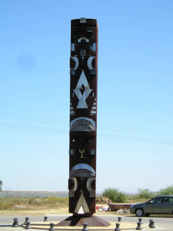 an intricate totem pole is near a parking lot