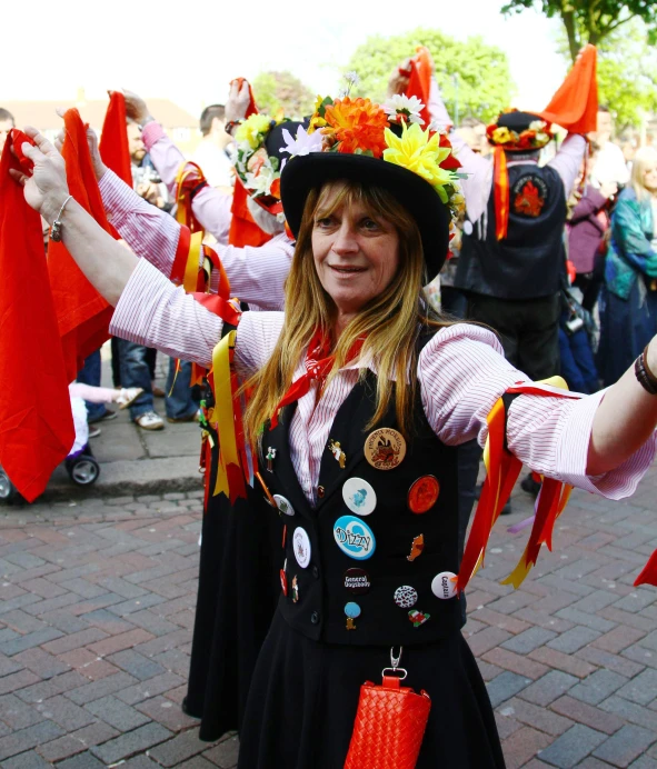 a woman in a costume holds up a red scarf
