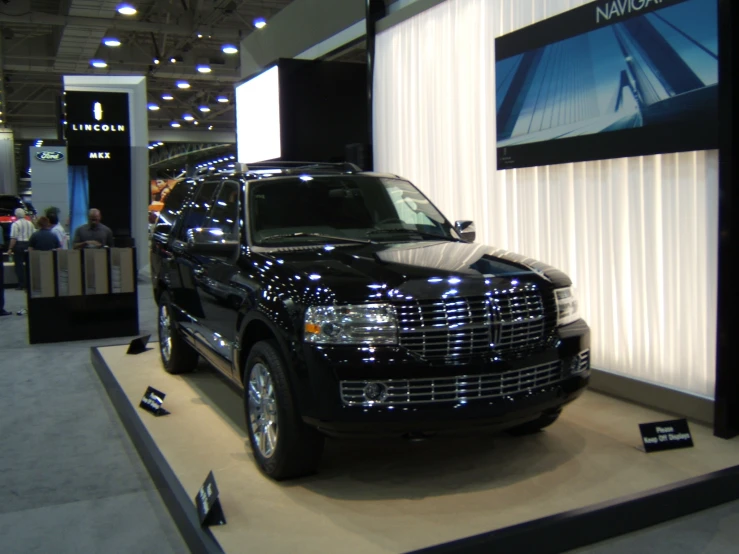 a black suv is parked inside a show room