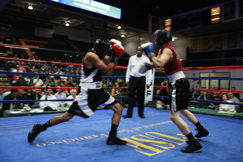 two boxers fighting in the ring on a boxing match