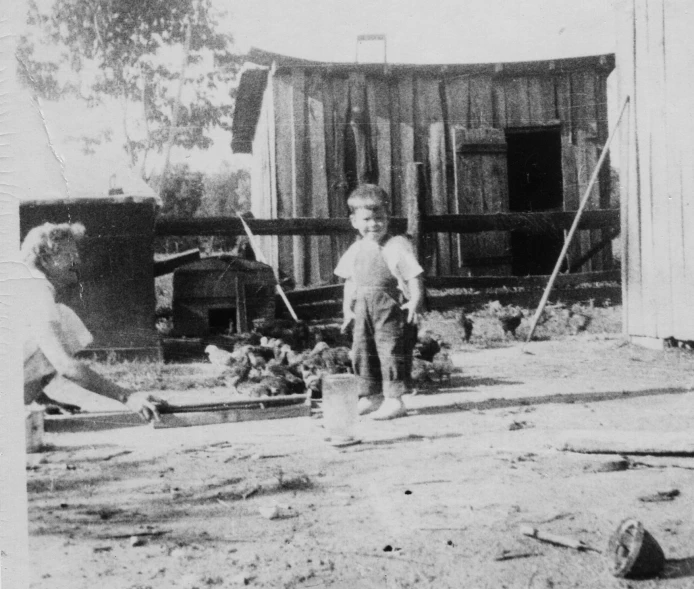 a black and white po of children in front of shack