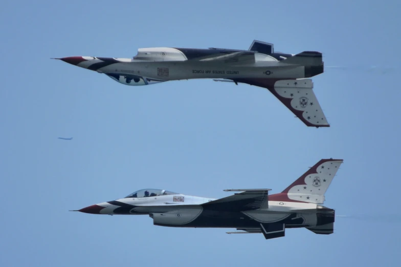 two fighter jets flying side by side through the sky