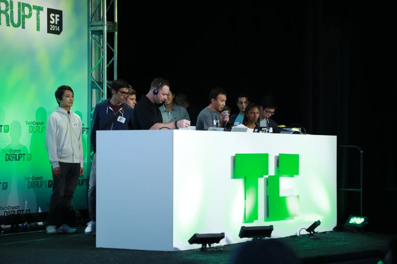 many people sitting at a table talking on a stage