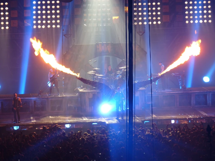 some fans and two light torches on a stage