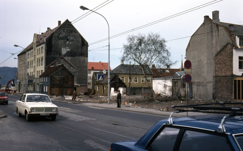 a white car driving down a street with buildings