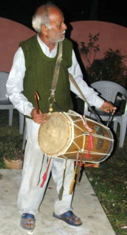 a man standing next to a table with a drum