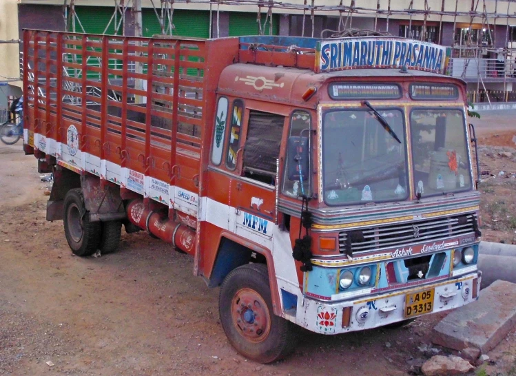 an old red truck parked next to a building