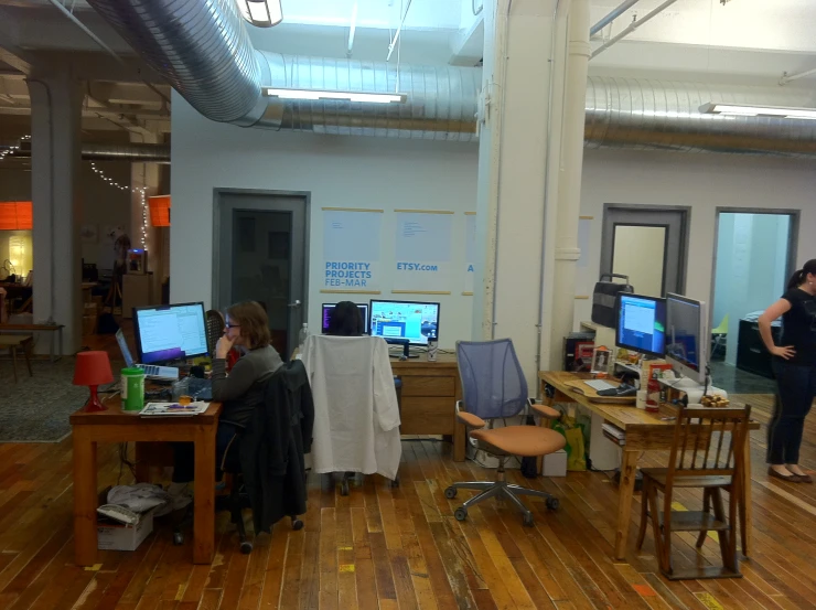 several people sitting around a wooden desk in a room