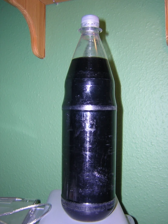 an old, plastic soda bottle on top of a white toilet