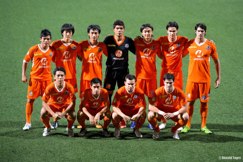 a team of soccer players pose for a group po