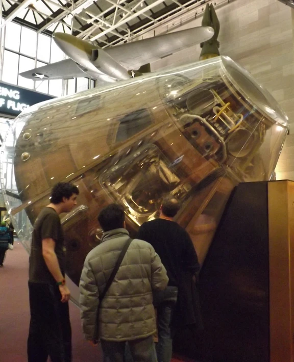 two men looking at a shiny object in a museum