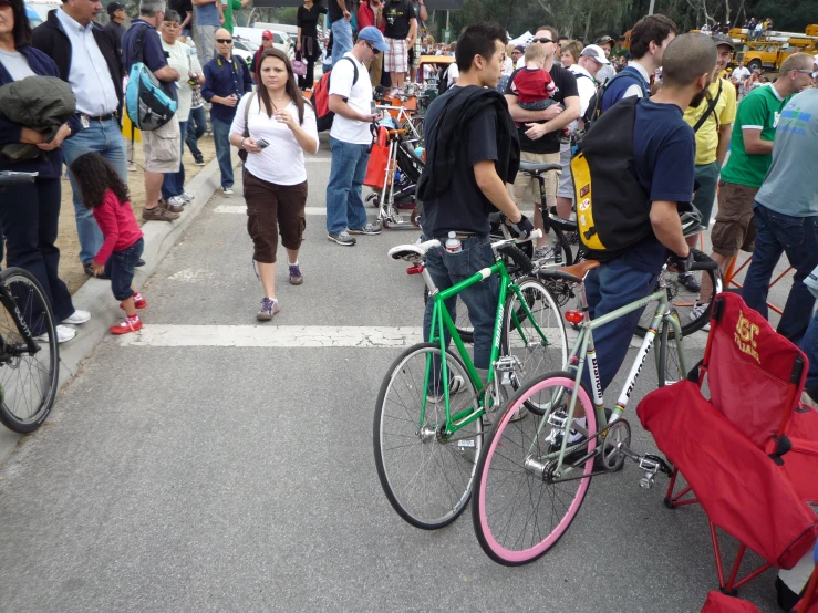 several people walking down the road, riding bicycles