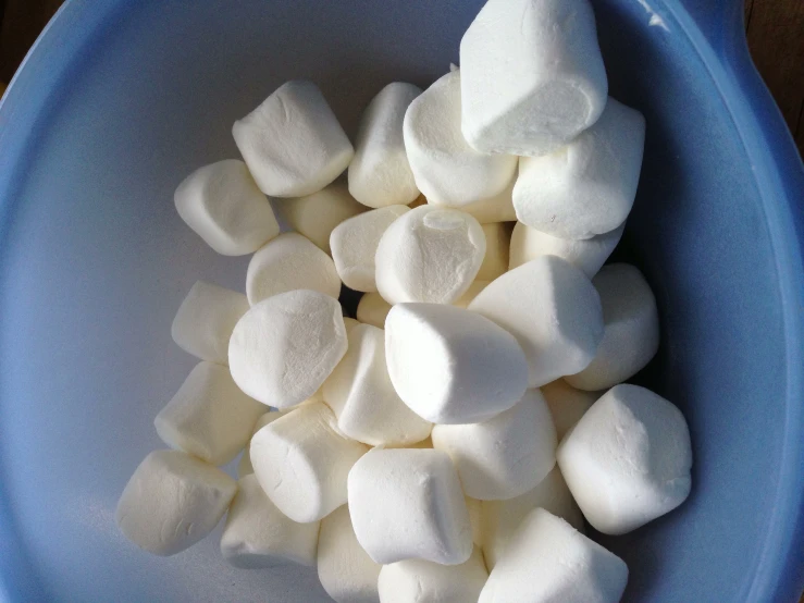 a bowl of marshmallows on a wooden table