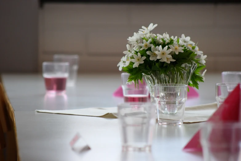 a glass filled with flowers on top of a table