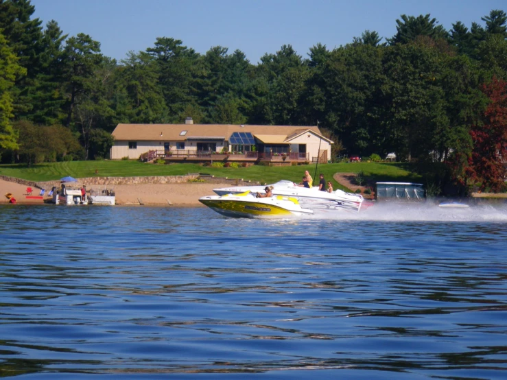 a boat traveling down the river, with a house in background