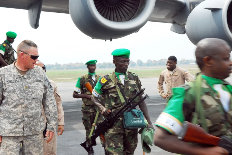 a man standing on the runway talking to soldiers