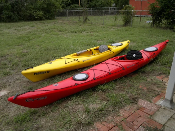 two boats are laying side by side in the grass