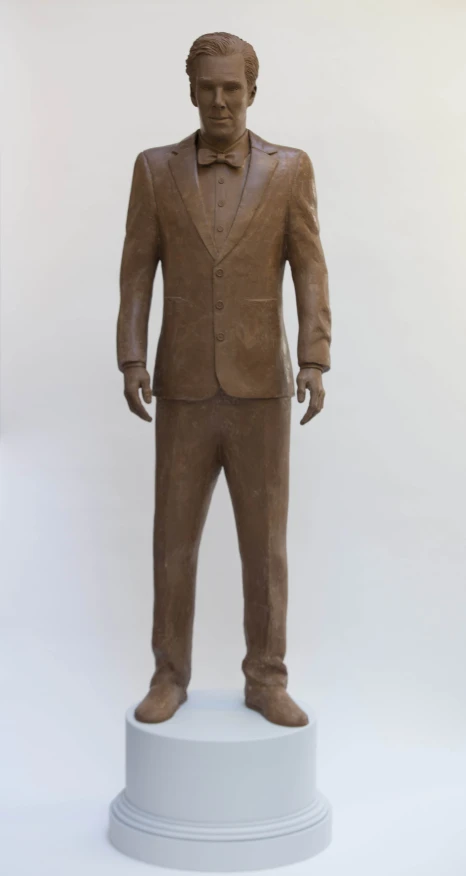 a statue of a man in a suit and tie standing on a pedestal