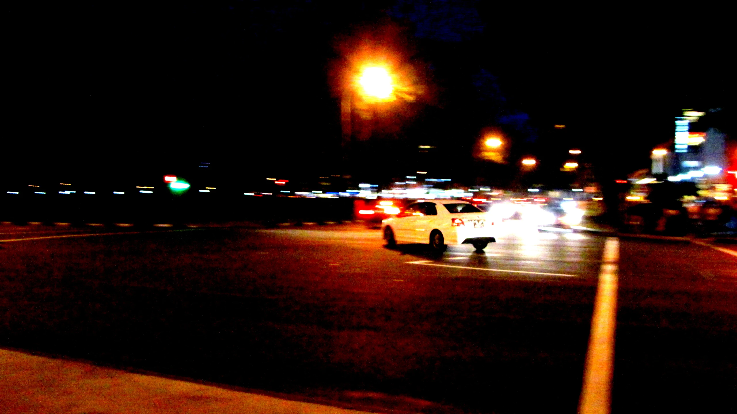 several cars driving on a city street at night