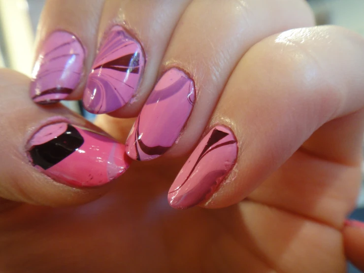 woman showing pink and black manicure on her nails