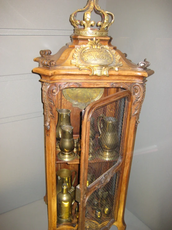 an old fashioned wooden cabinet holding a clock
