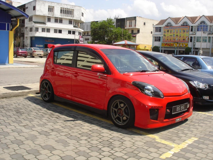 some cars parked on a city street and next to other cars