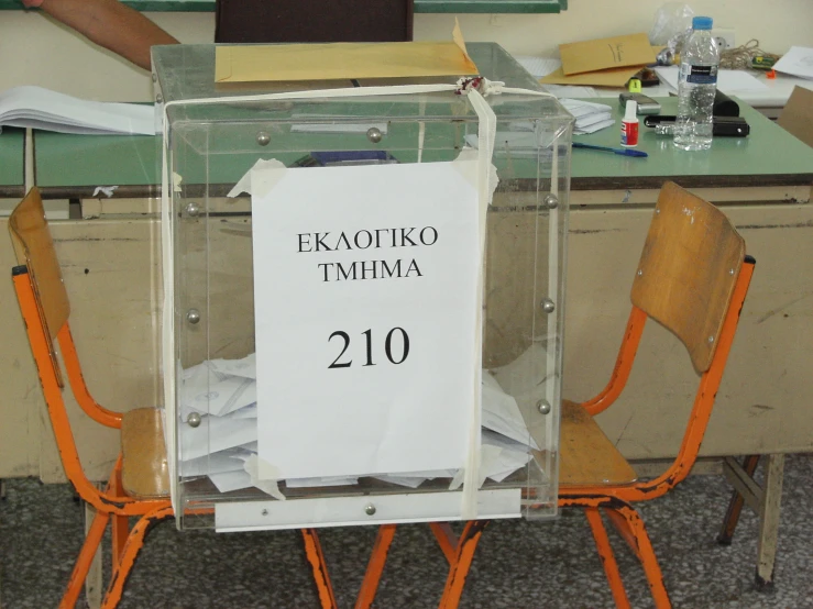 a sign sitting on top of an empty desk