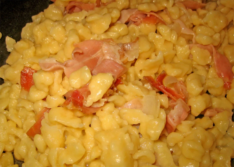 macaroni with ham and other foods on the side