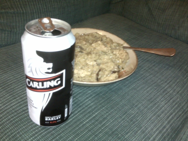 a can of carings sits next to a bowl of food on a green couch