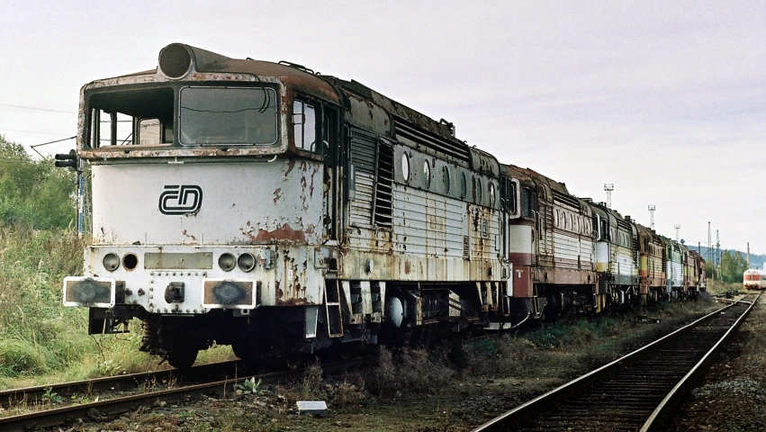 an old train on a railroad track that is rusty