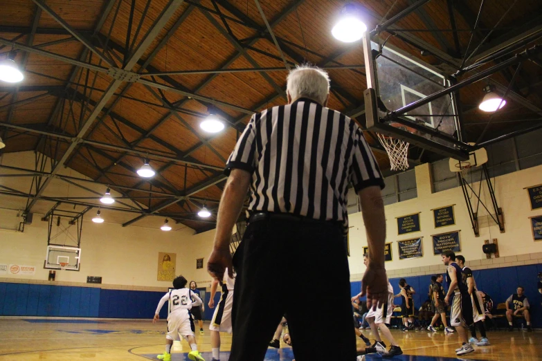 a basketball game in progress with the referee and ball