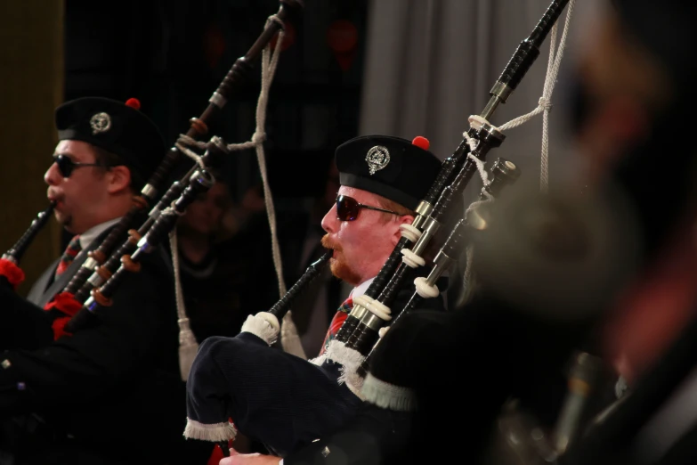 a man in uniform holds a bagpipe behind his back