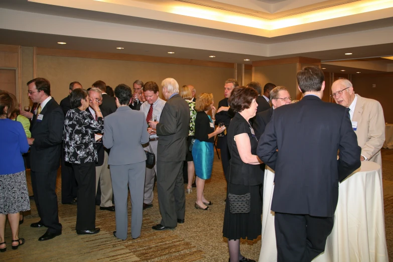 a crowd of people standing in a hallway next to each other