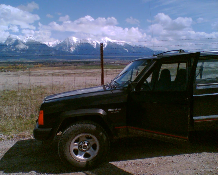 a black truck sitting in front of a field