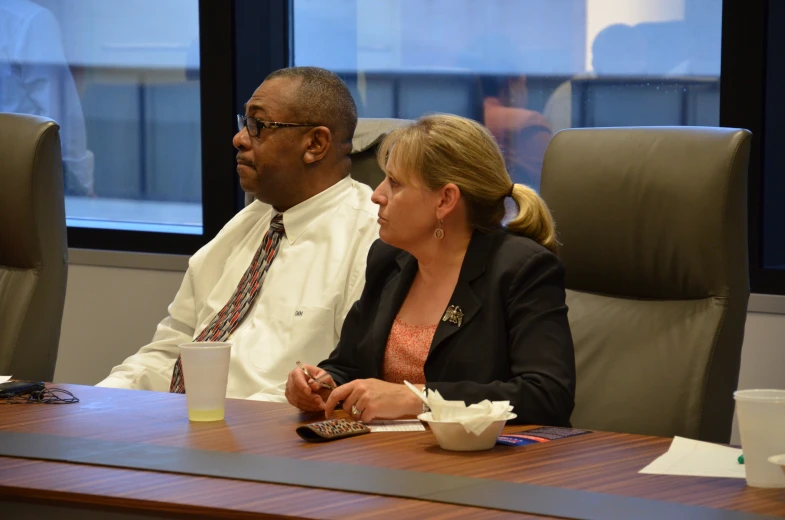 a man and woman in business attire sitting at a desk