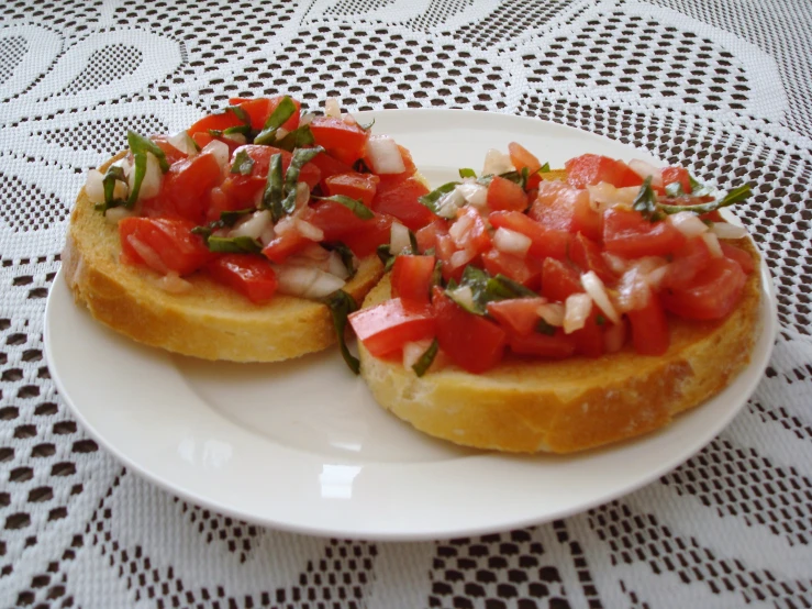 two toasted white bread topped with fresh chopped tomatoes and onions