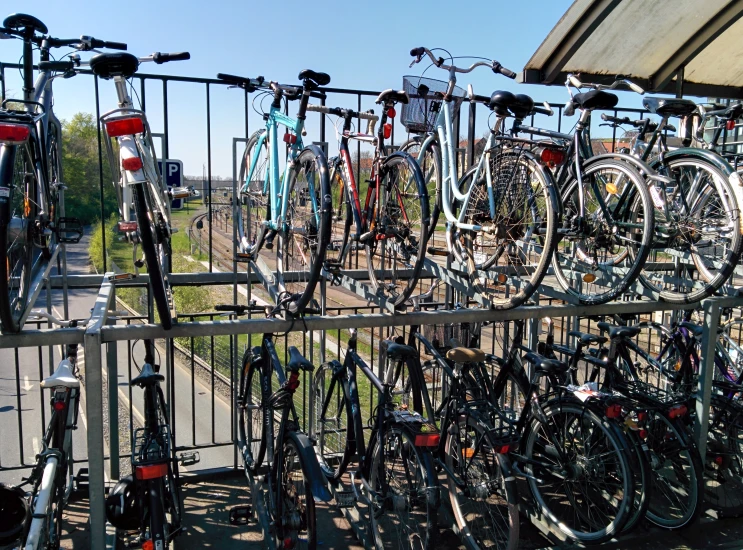 an array of bicycles parked next to a fence