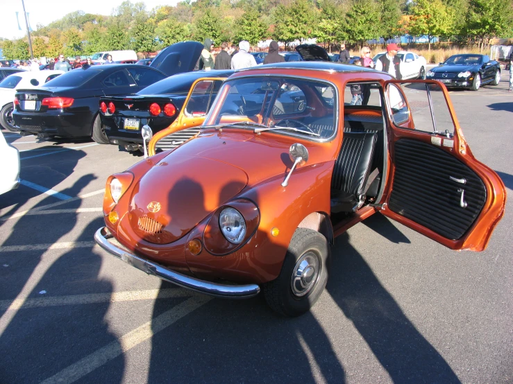 an old orange vw beetle in a parking lot