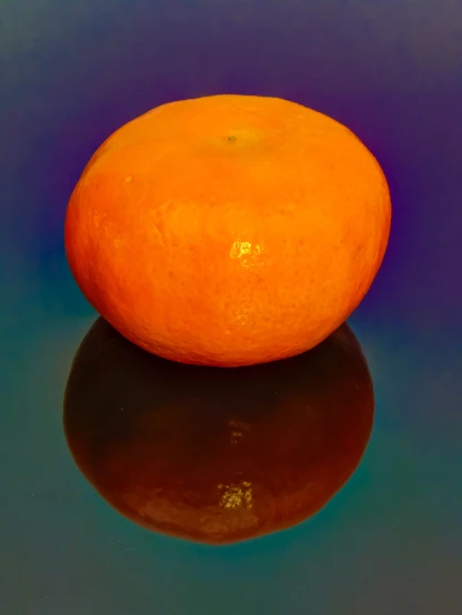 an orange sitting on a table top with reflections