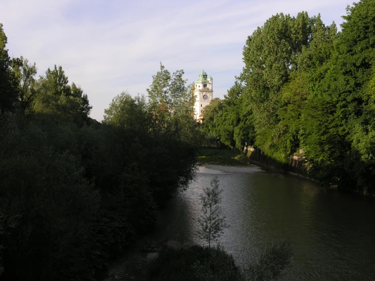 a lake with trees and buildings in the distance