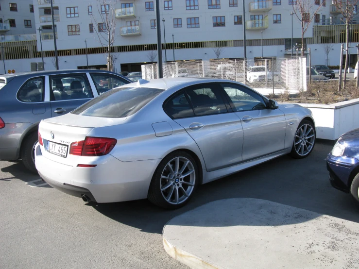 silver bmw car parked next to a group of parked cars