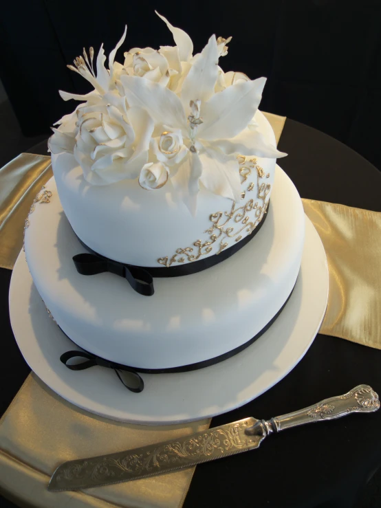 white cake with flowers and a ribbon on top