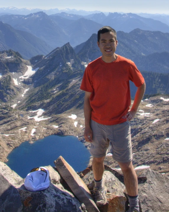 the man is posing on the top of the mountain